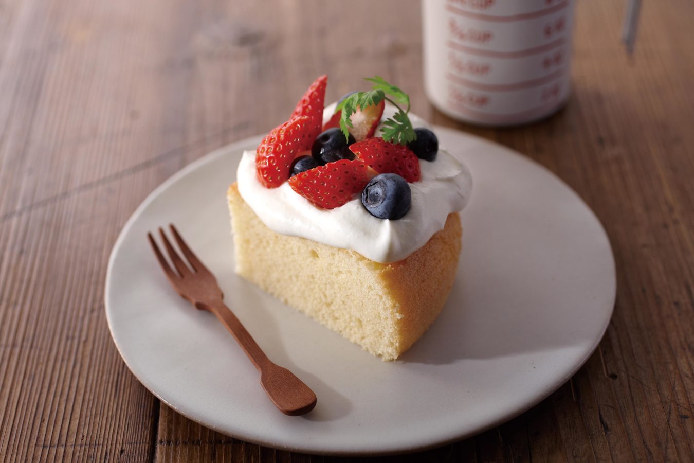 Slice of rice cooker sponge cake with whipped cream and berries